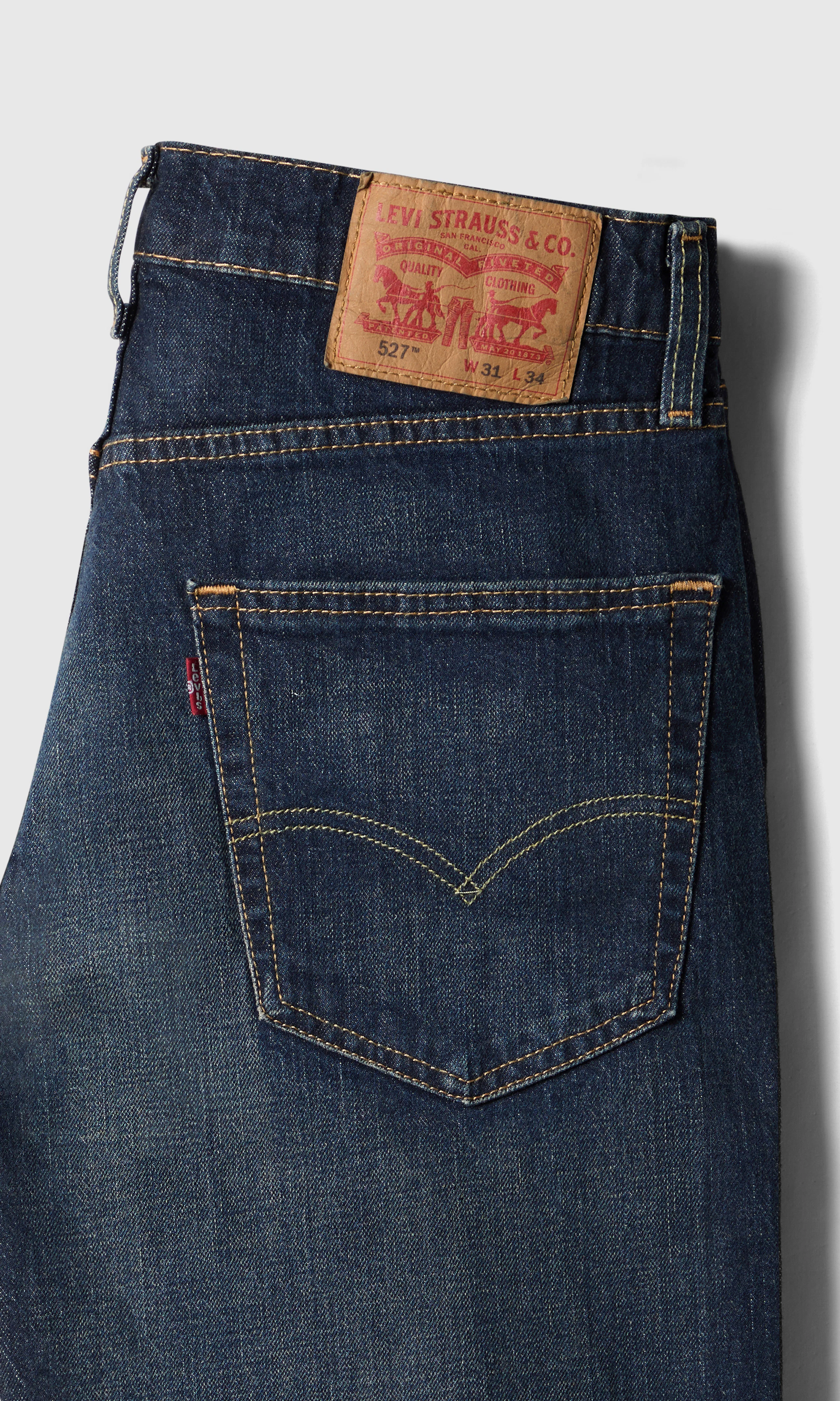 527™ Slim Bootcut Tummansiniset Farkut. Detail 1. Flat.